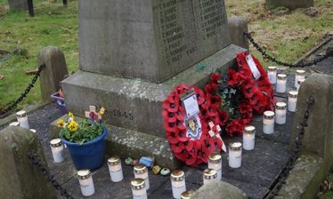 Wreaths and candles around the base of the Marston War Memorial.