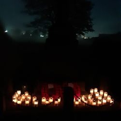 Remembrance candles glowing beside the Marston War Memorial at night.
