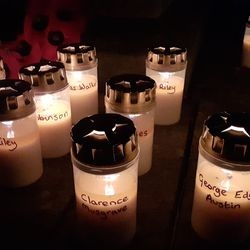 Close-up of lit remembrance candles bearing soldiers' names.
