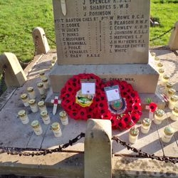 Poppy wreaths and small remembrance crosses around the memorial.