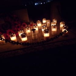 Rows of remembrance candles illuminated beside the memorial.