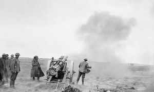 An artillery crew firing a field gun.