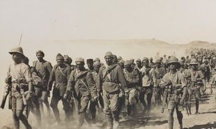Troops marching with camels.