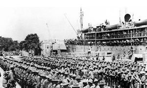Troops gathered beside a troopship.