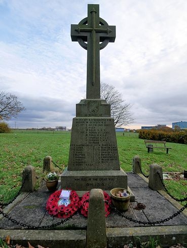 The Marston War Memorial with poppy wreaths at its base.