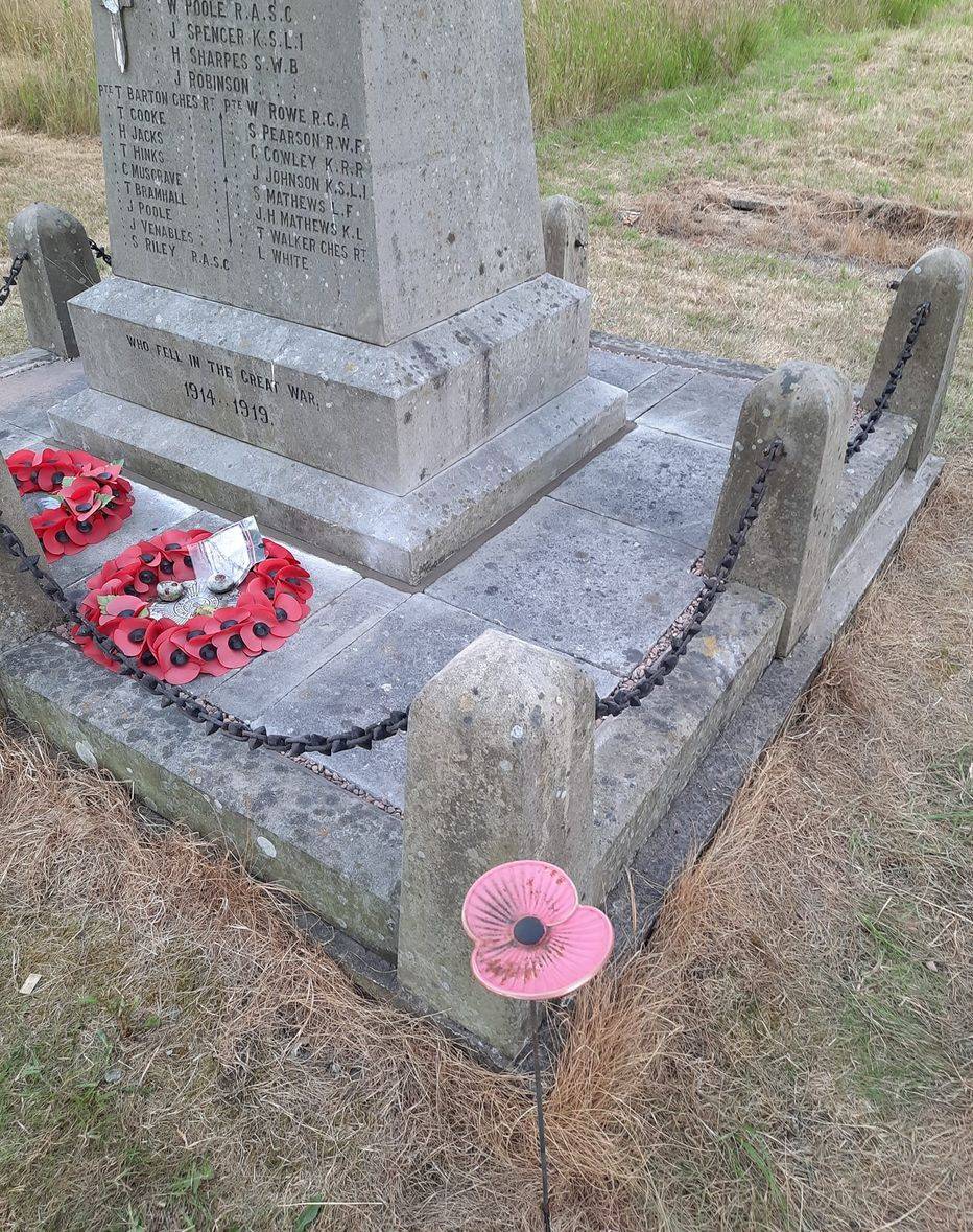 Detail of the repaired memorial base with poppy wreaths.